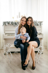 Happy smiling family at  studio on background of the Christmas tree with gift