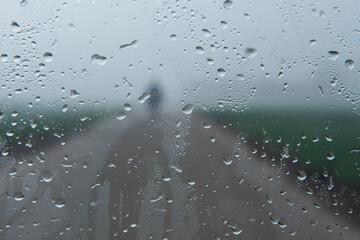 road in the rain. Rain drops on the transparent Glass Window