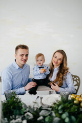 Happy smiling family at  studio on background of the Christmas tree with gift