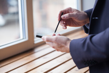 Mobile phone and stylus in male hands