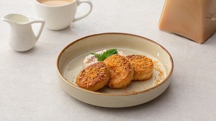 Portion of sweet russian pancakes syrniki with cream
