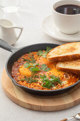 Pan of cooked shakshuka middle eastern dish with bread