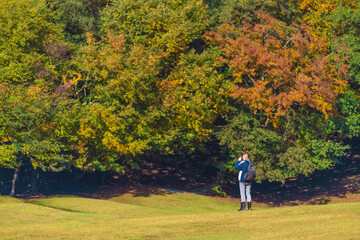 Fototapeta premium Photographer naturalist takes pictures of autumn forest