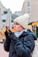 Girl send voice message of the phone in the street, in winter.