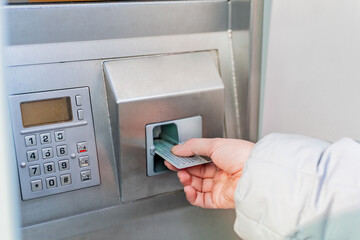 Female hand with card. Woman using an ATM.