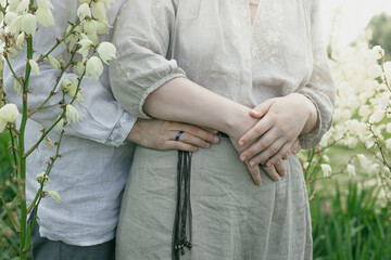 Close up lovers embrace concept photo. Summertime. Side view photography with blooming flowers in meadow on background. High quality picture for wallpaper, travel blog, magazine, article