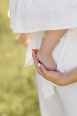 Young family with cute little daughter walking in forest on the sunset