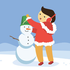 A boy in winter headphones puts a bucket on a snowman's head