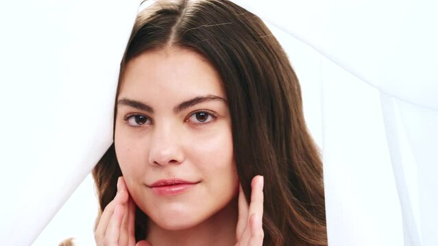 Beauty, skincare and creative with woman and fabric for skincare, fresh and silk texture. Curtain, art and textile with irl model and massage for facial in studio for fashion, luxury and makeup