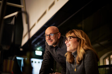 Group of business people working on computer together in office in late evening