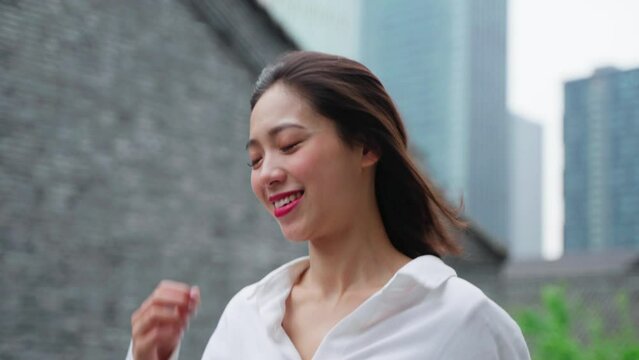 charming happy young asian woman running in the urban city slow motion joyful woman
