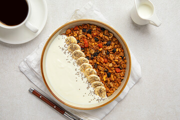 Portion of gourmet granola breakfast with banana and yoghurt