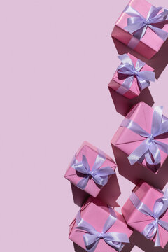 Gifts in modern, stylish boxes on a delicate pink background. Holiday concept, copy space.