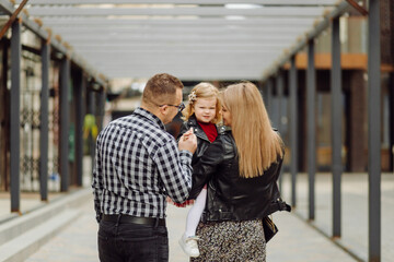 Fototapeta na wymiar Parents and daughhter walking around the city. Spend time together. They are happy