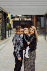 Fototapeta premium Parents and daughhter walking around the city. Spend time together. They are happy