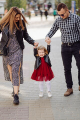 Parents and daughhter walking around the city. Spend time together. They are happy