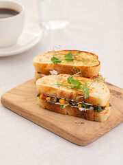 Portion of appetizing tuna sandwich with corn and herbs