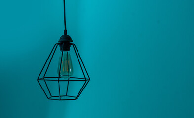 Lamp shade of metal wires hanging colored background