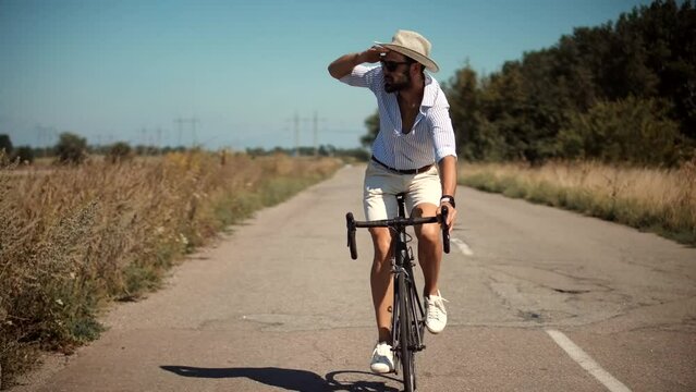 man in hat look into distance on bicycle
