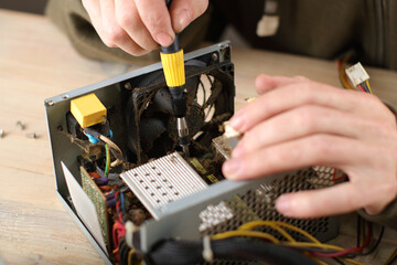 person checking computer power supply on table