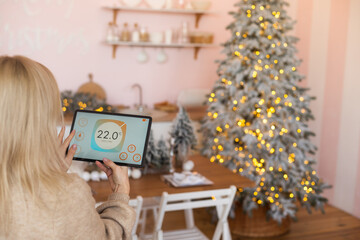 Young woman using application in his smart home at Christmas