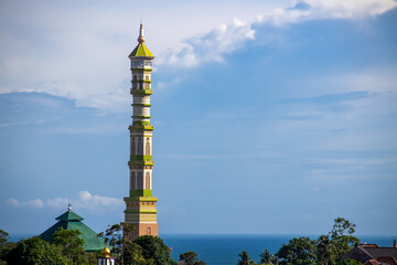 Fototapeta premium The mosque's domed minaret against the background of blue clouds