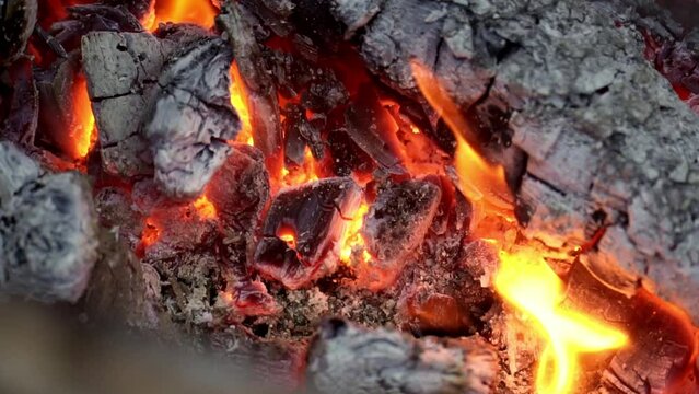 Close up shot of burning and hot charcoal coals. slow motion.