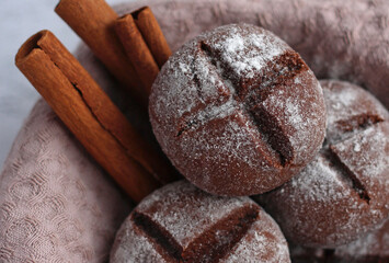 round homemade gingerbread with cinnamon and powdered sugar on a gray background