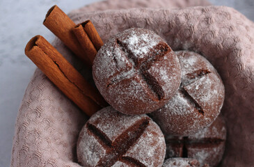 round homemade gingerbread with cinnamon and powdered sugar on a gray background