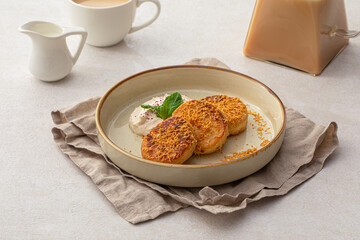 Portion of sweet russian pancakes syrniki with cream