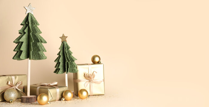 Decorative Christmas trees, balls and gifts on beige background with space for text