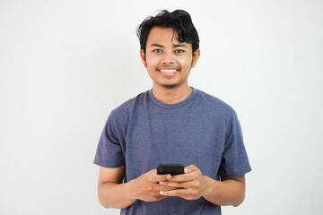 handsome smiling or happy Asian young man casual outfit in Navy t-shirt holding smart phone chatting on white isolated background.