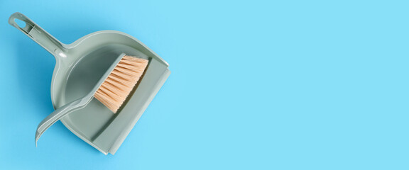 Dustpan and brush on light blue background with space for text, top view