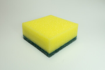 green and yellow dishwashing sponge on a white background