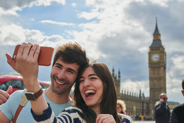 Travel, phone and couple take a selfie in London to post outdoor city street content on social...