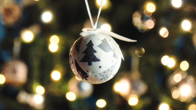 Hanging the White Christmas ball on the tree point of view