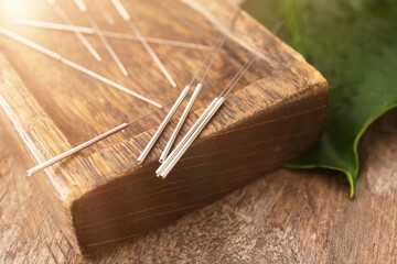 Stand with acupuncture needles on wooden background, closeup - obrazy, fototapety, plakaty