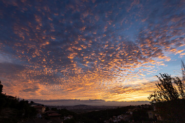 Golden sunrise on altocumulus clouds over houses - obrazy, fototapety, plakaty