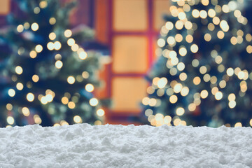 Empty white snow with blur Christmas tree with bokeh light background
