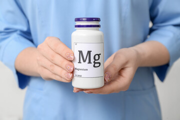 Female doctor holding bottle of magnesium pills, closeup