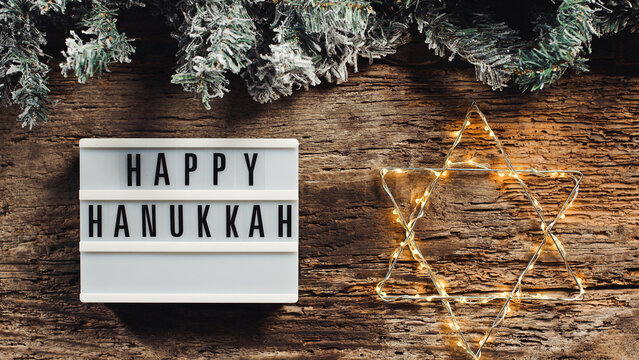 Happy Hanukkah signboard on wooden background