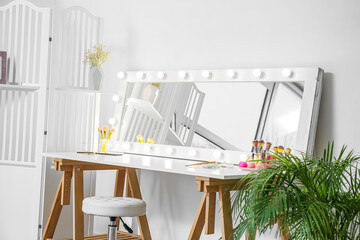 Modern workplace of makeup artist with mirror and decorative cosmetics in light room