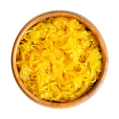 Sweet golden curry mango sauerkraut, in a wooden bowl. Finely cut cabbage, fermented by lactic acid...