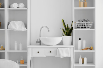 Obraz na płótnie Canvas Modern sink and shelf units with bath accessories near white wall