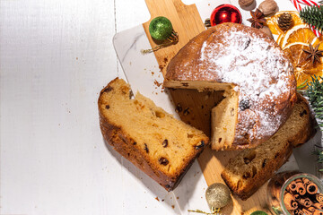 Traditional Christmas panettone cake with dried fruits, spices, Christmas tree and decoration on rustic wooden background 