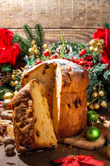 Traditional Christmas panettone cake with dried fruits, spices, Christmas tree and decoration on rustic wooden background 
