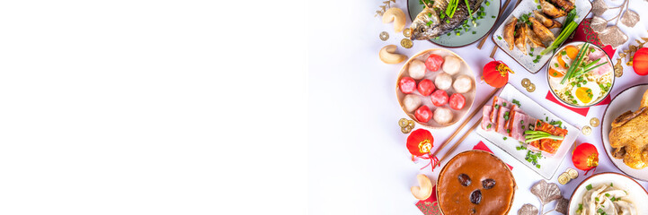 Traditional Chinese lunar New Year dinner table, party invitation, menu background with pork, fried fish, chicken, rice balls, dumplings, fortune cookie, nian gao cake, noodles, chinese decorations