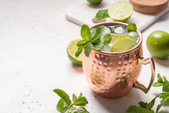 Moscow mule alcoholic cocktail in copper mug with lime, mint and cucumber