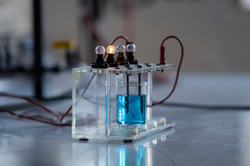 electrolyte solution turns on a light bulb. Experiment in the chemistry laboratory