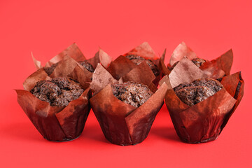 Tasty chocolate muffins on red background